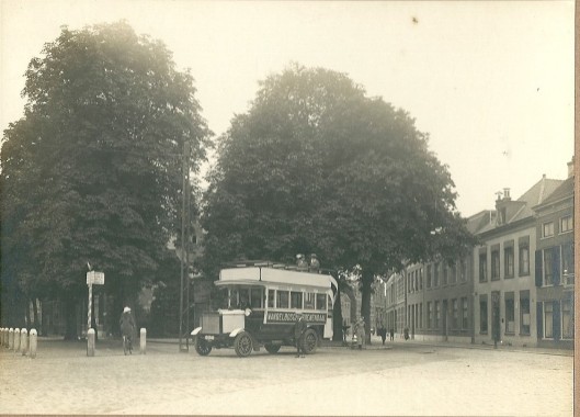 De bus rijdt Haarlem binnen met twee mannen op de imperiaal
