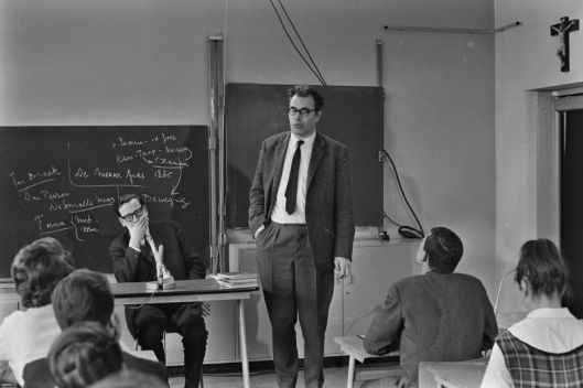 Godfried Bomans bij een bezoek aan der derde klas van het Haarlemse Mendel-college. Links de leraar Nederlands F.X.Koot. Uitgezonden in AVRO-televisieserie 'Uit de school geklapt', 25 februari 1964