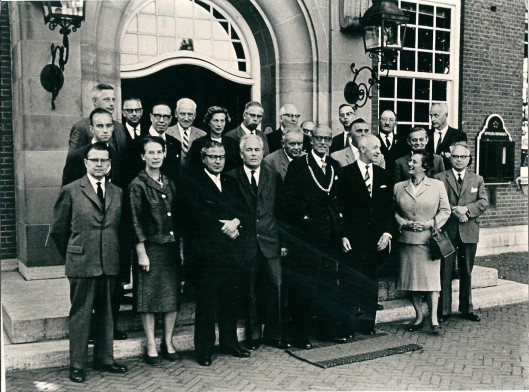 Het gemeentebestuur van Heemstede in september 1962 gefografeerd voor de ingang van het raadhuis. Bovenste rij v.l.n.r.: ir. D.Enschedé, ir. J.Kooijmans, M.Scheer, mr.E.Minderop, mr.K.Pliester, P.Zegwaard, mr.J.Rutgers, N.van der Linden en ir.C.Frets. Middelste rij: ing.M.van der Hulst, J.Corver, mr.drs.E.Vriesendorp-de Clercq, Th,Verhoeven, C.Brandsma en G.Willemse. Vooste rij: J.Heupers, mw.H.v.d.Meulen-Houwer, mr.O. van Wijk, Th.Bekker, burgemeester mr.A.ridder van Rappard, secretaris A.van Wingerde, mw.drs.H.Cohen-Kosten en H.Verkouw.
