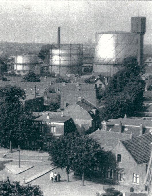 Wilhelminaplein omstreeks 1934 vanaf de kerktoren. Vooraan caf◙ Het Wapen van de Haarlemmermeer. Verderop de drie gashouders van de gasfabriek en de watertoren. Foto uit omstreeks 1934.
