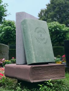 Drie boeken van natuursteen op een graf in Noord-Brabant (Fleuren)